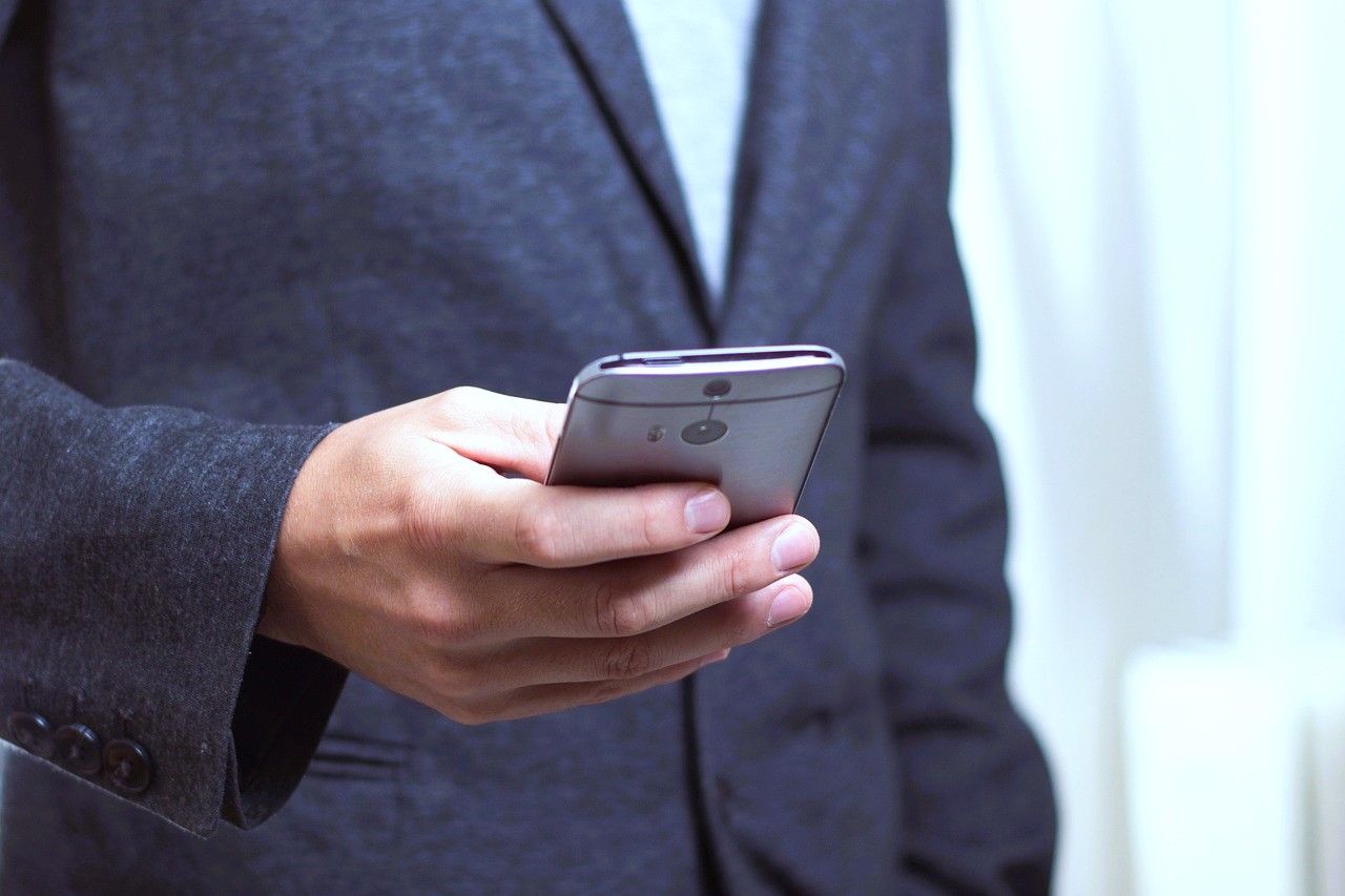 telephone-586268_1280 Businessman, der auf sein Smartphone sieht